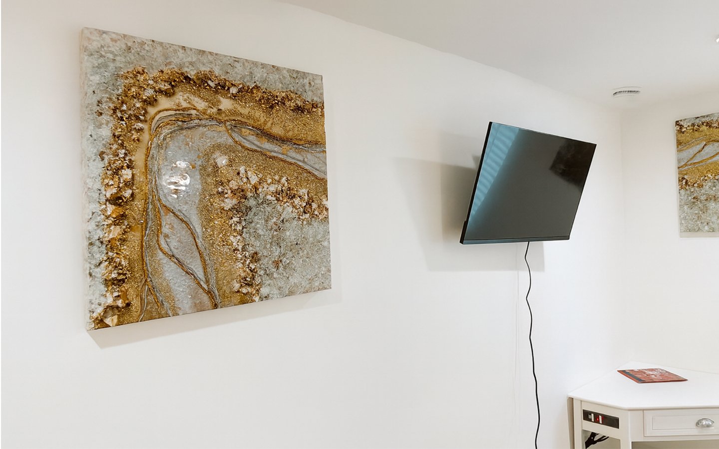 Wall-mounted Smart TV and corner desk area in The Gold Room, perfect for streaming, reading, or catching up on work during your stay.