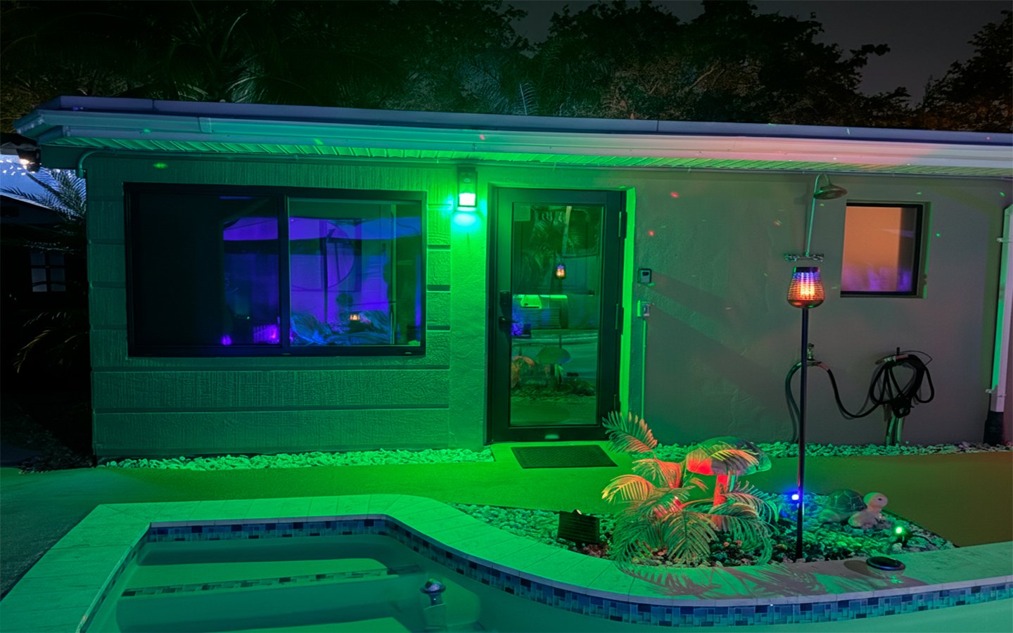 Night exterior view of The Green Room at Garden of Manors, featuring ambient lighting and poolside surroundings.
