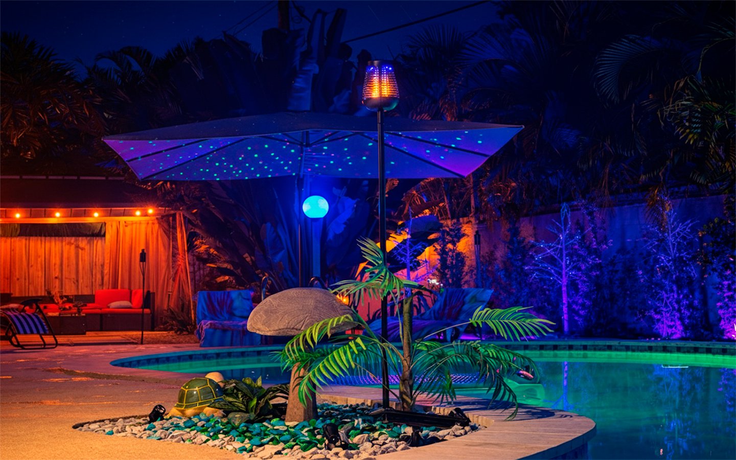 An inviting nighttime pool setting at Garden of Manors, with ambient lighting and lush tropical landscaping.