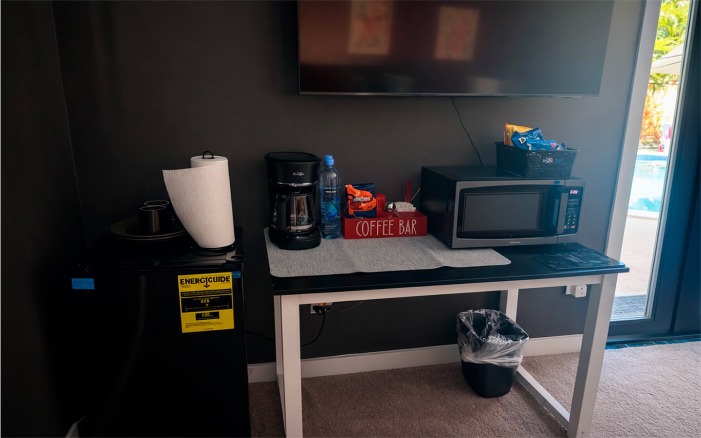 In-room amenities in The Red Room, including a coffee station, microwave, mini fridge, and flat-screen TV.