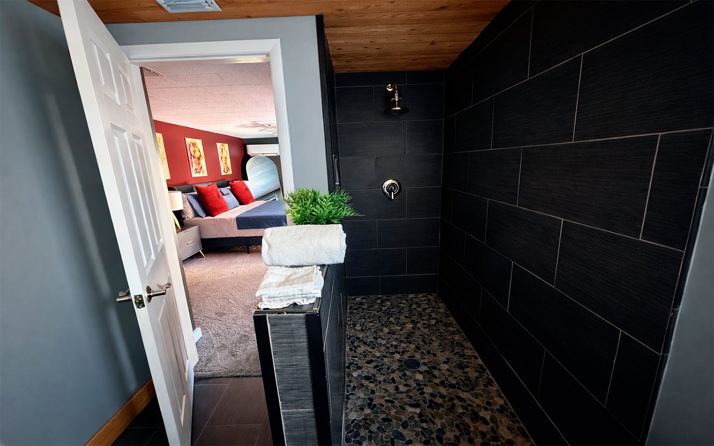 Modern en-suite bathroom in The Red Room, featuring a sleek walk-in shower with dark tile finishes and a clean, contemporary design.