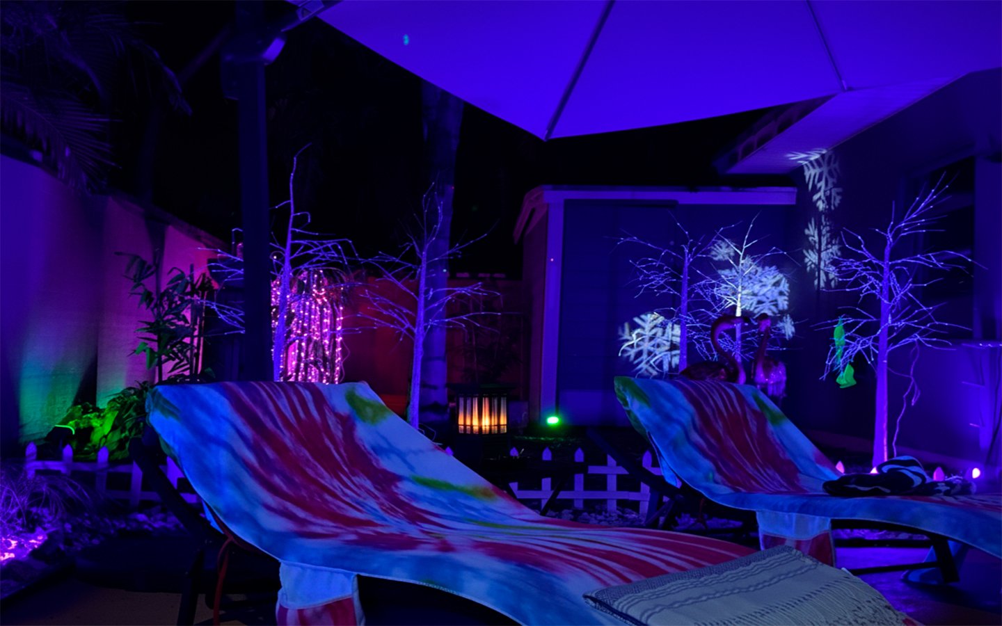 Poolside lounge seating at Garden of Manors, softly illuminated at night, offering a relaxed space to unwind under the stars in a private tropical setting.