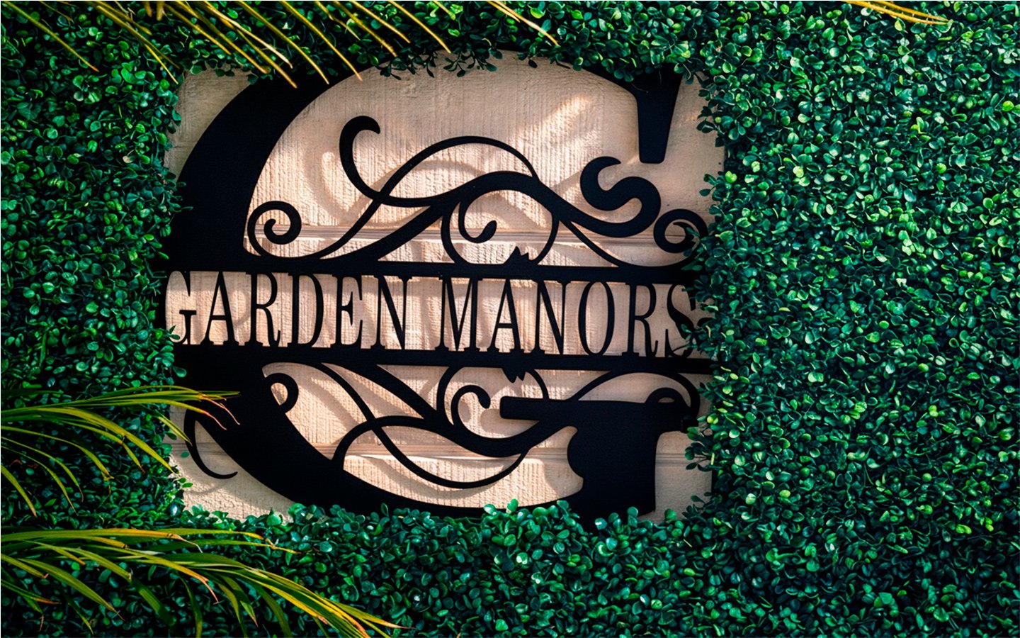 Welcome to Garden of Manors—our iconic sign surrounded by tropical greenery in the heart of Wilton Manors.
