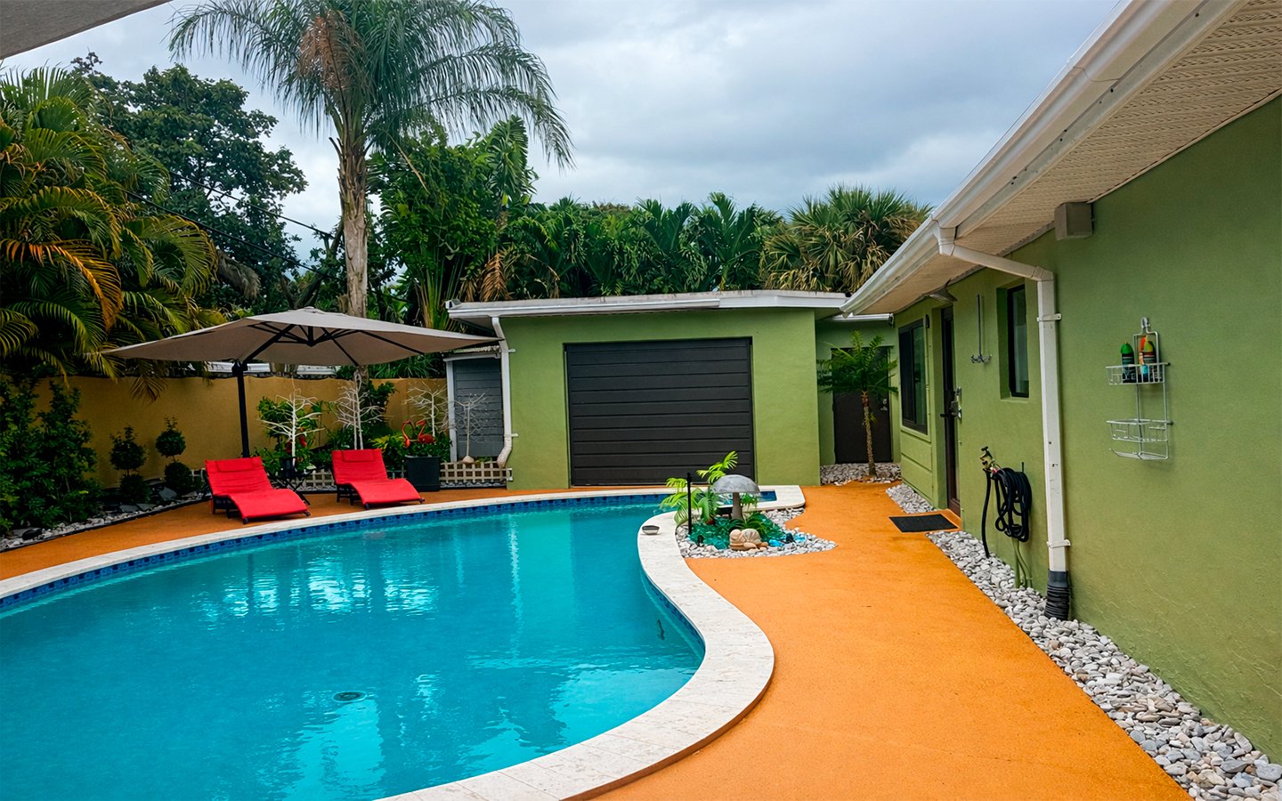 Heated, clothing-optional pool surrounded by lush tropical landscaping.
